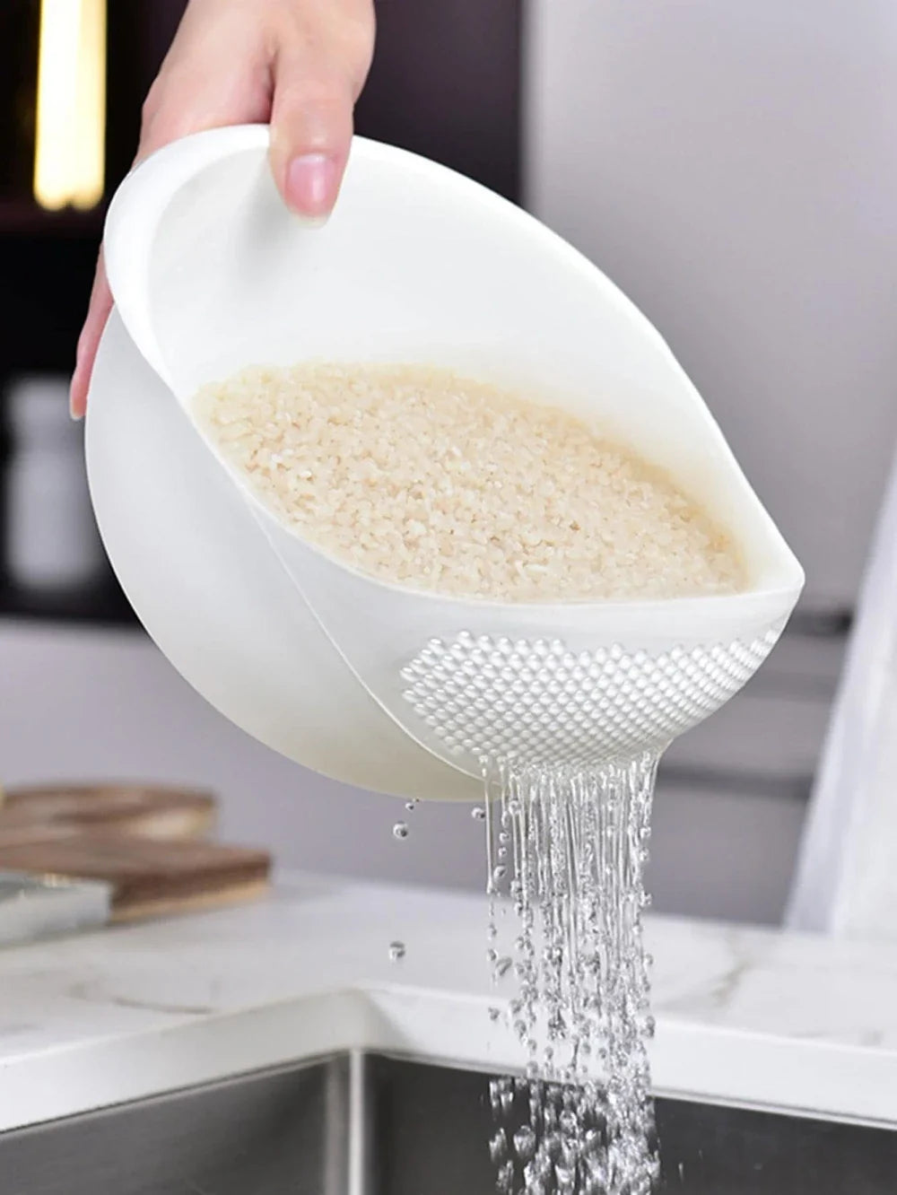 Rice washing drain basket rinsing rice in the kitchen sink