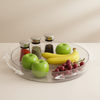 Clear rotating tray holding fruit and spice jars