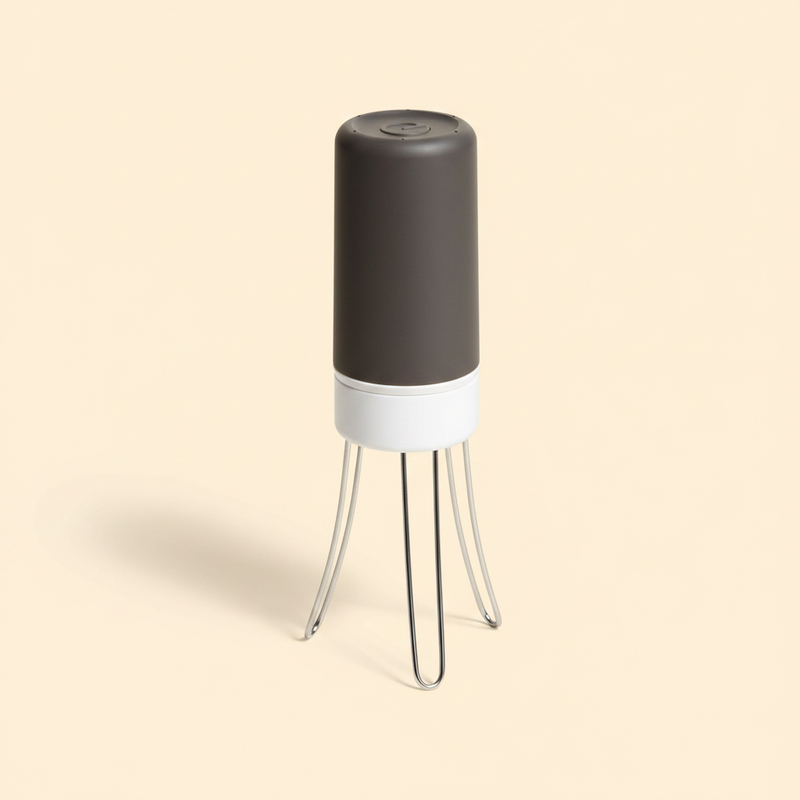 Hands-free automatic three-leg pan stirrer on a cream studio background